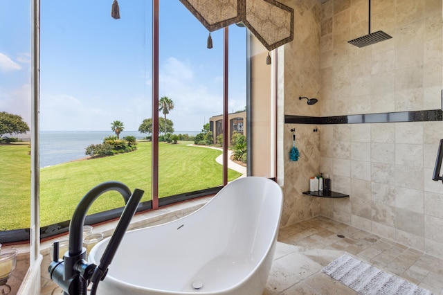 bathroom with a soaking tub, stone finish floor, a water view, and a shower stall