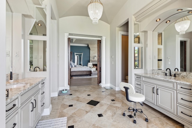 bathroom featuring tile patterned floors, vaulted ceiling, and dual vanity