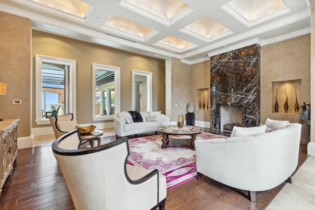 living area featuring coffered ceiling, dark wood-style floors, a fireplace, and crown molding