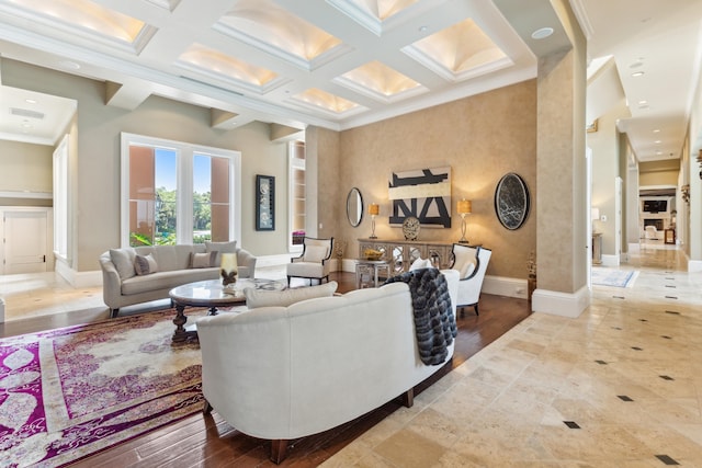 living room featuring coffered ceiling, baseboards, visible vents, and a towering ceiling