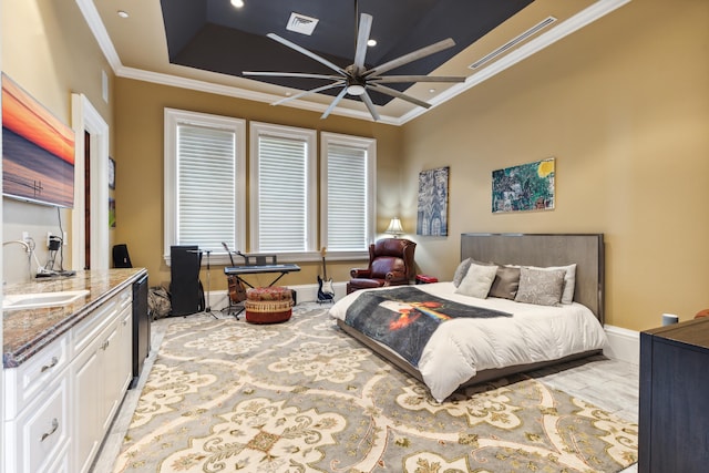 bedroom featuring baseboards, visible vents, ornamental molding, and a sink