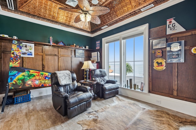 sitting room with an ornate ceiling, a ceiling fan, visible vents, ornamental molding, and hardwood / wood-style floors