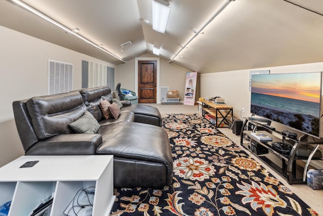 home theater room featuring lofted ceiling, rail lighting, and light colored carpet