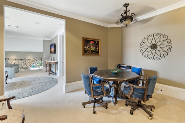 dining room featuring ceiling fan, light carpet, and ornamental molding