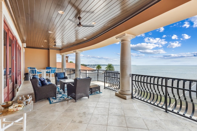 exterior space with ceiling fan, a balcony, and a water view