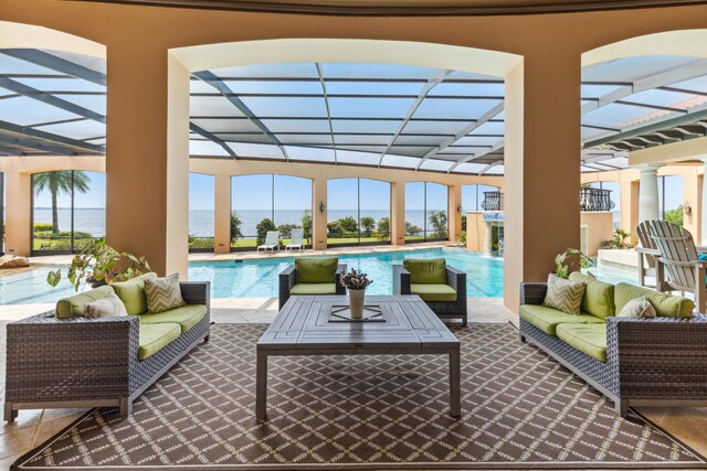 view of patio / terrace with outdoor lounge area, a water view, a lanai, and an outdoor pool