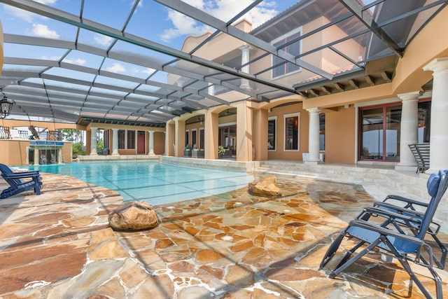 view of swimming pool with glass enclosure and a patio area