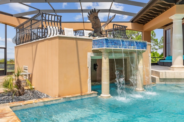 view of pool with glass enclosure and pool water feature