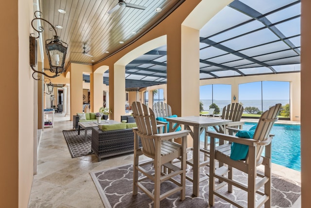 view of patio with glass enclosure and an outdoor pool