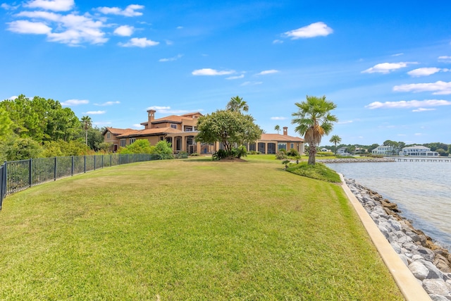 view of yard featuring a water view and fence