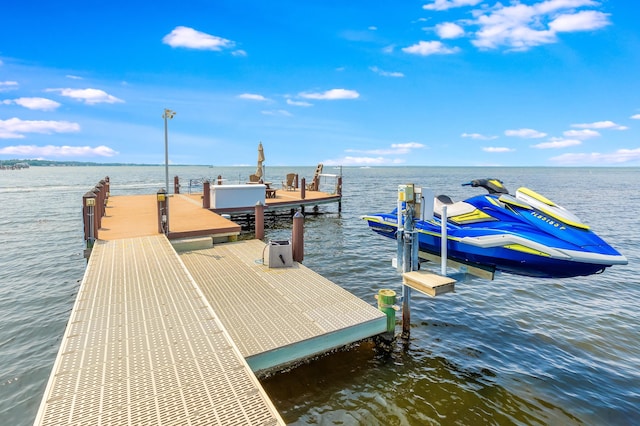 dock area featuring boat lift and a water view