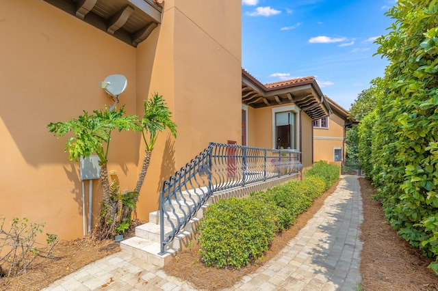 view of home's exterior with stucco siding and a tile roof