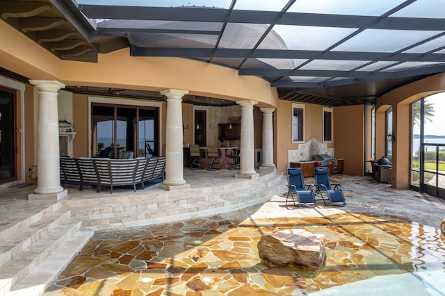 view of patio featuring glass enclosure and outdoor dry bar