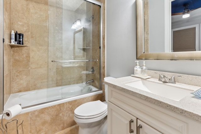 full bathroom with combined bath / shower with glass door, toilet, and vanity