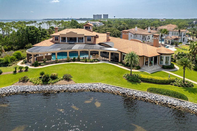 back of property with a water view and a yard