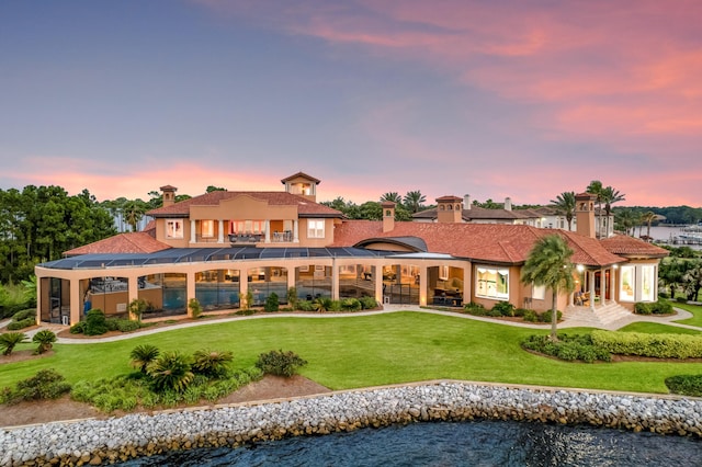 back of house with stucco siding, a balcony, a swimming pool, a yard, and a patio area