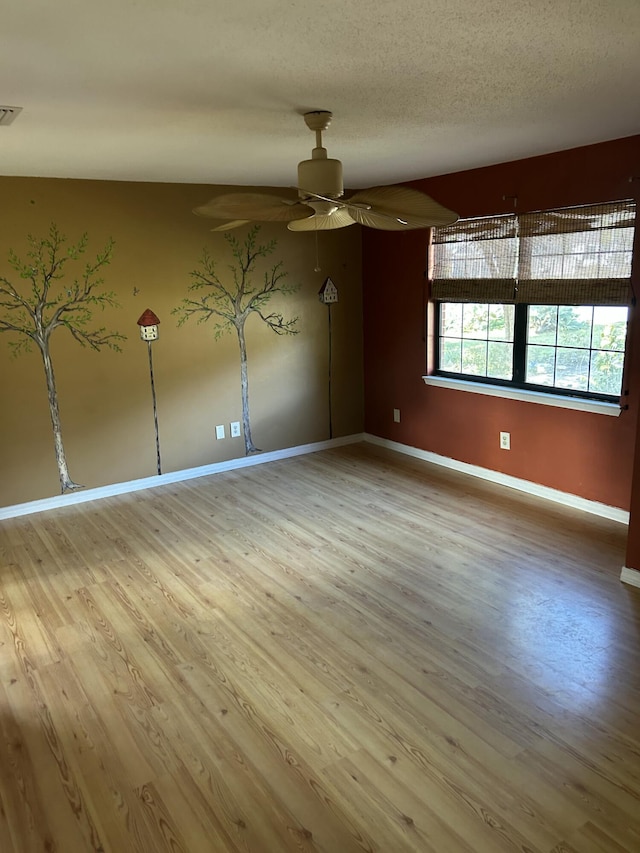 empty room with hardwood / wood-style flooring, ceiling fan, and a textured ceiling