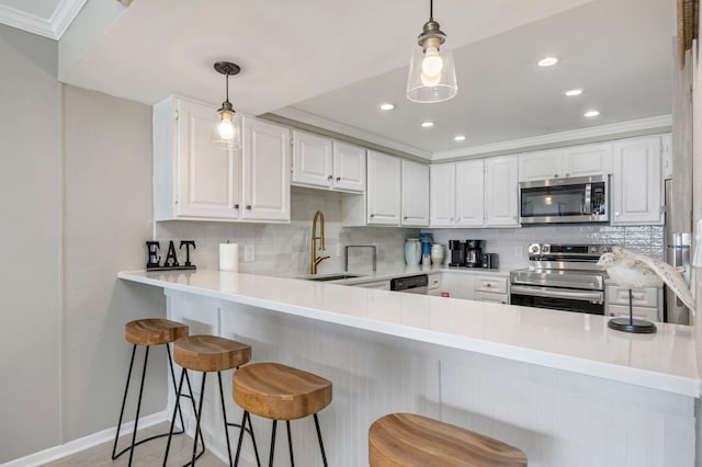 kitchen featuring appliances with stainless steel finishes, light countertops, crown molding, white cabinetry, and backsplash