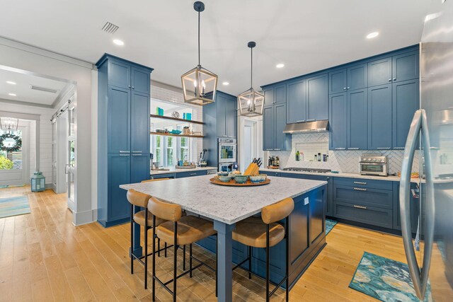 121 Shannon Dr, Santa Rosa Beach, FL 32459 - kitchen featuring visible vents, under cabinet range hood, and blue cabinetry