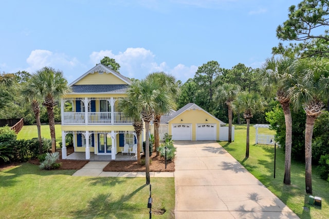 view of front of home with a garage, a balcony, a front yard, and covered porch