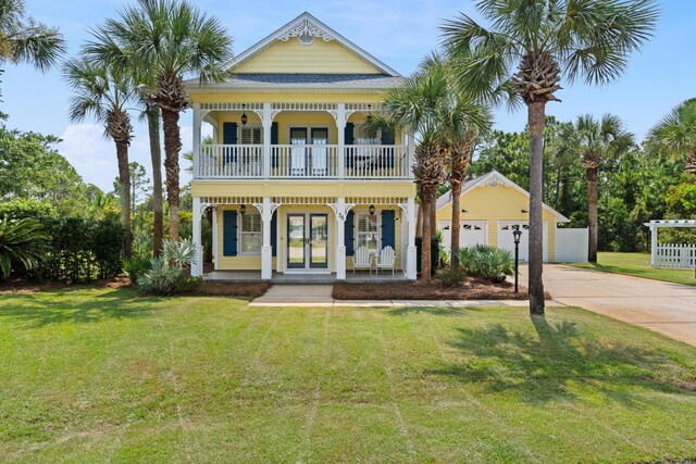 view of front facade featuring a porch, a garage, a front yard, and an outdoor structure