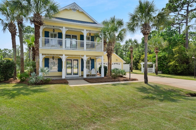 view of front of property with a garage, covered porch, and a front lawn