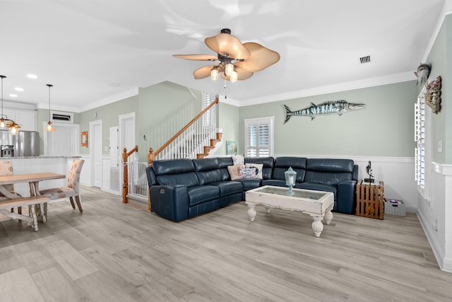 living room with crown molding, ceiling fan, and light hardwood / wood-style floors