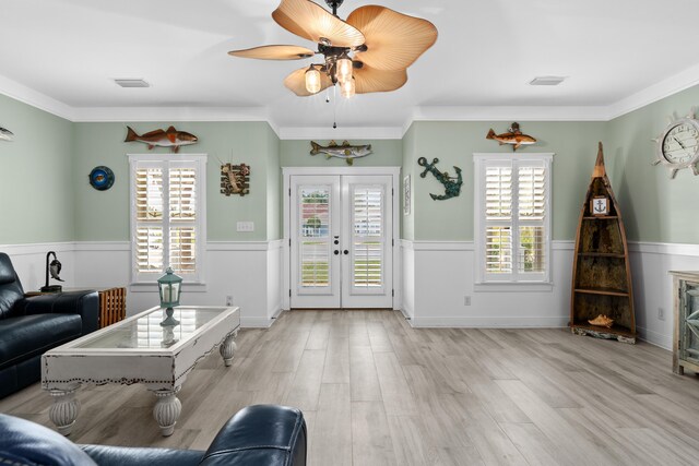 unfurnished living room featuring french doors, plenty of natural light, ornamental molding, and light hardwood / wood-style floors