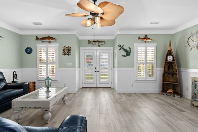 unfurnished living room with ornamental molding, light hardwood / wood-style flooring, ceiling fan, and french doors