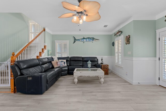 living room with crown molding, ceiling fan, and light hardwood / wood-style floors