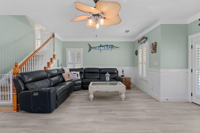 living room featuring crown molding, ceiling fan, and light hardwood / wood-style flooring