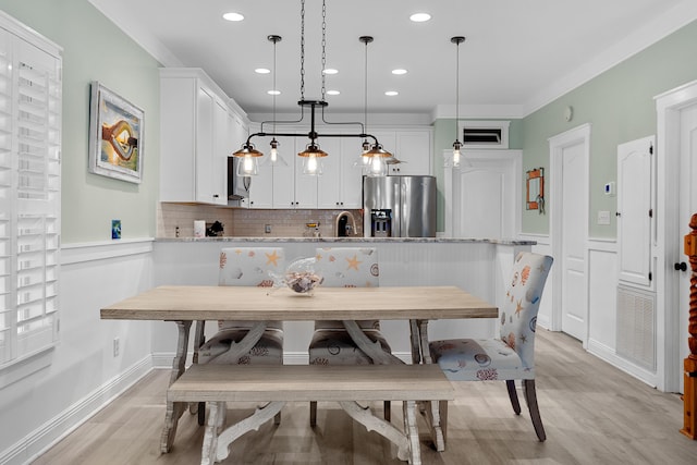 dining room with breakfast area, sink, and light hardwood / wood-style flooring