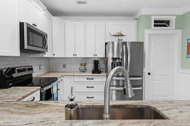 kitchen featuring appliances with stainless steel finishes, sink, tasteful backsplash, and white cabinets