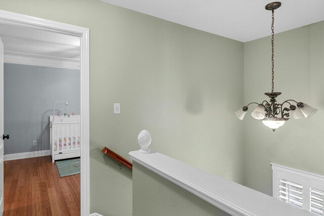 hall with hardwood / wood-style flooring and a chandelier