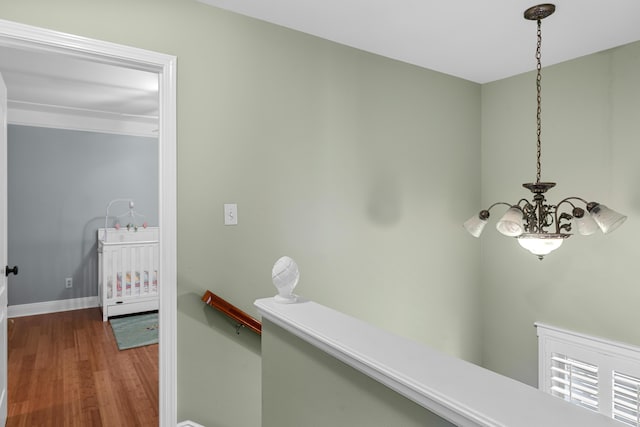 corridor featuring hardwood / wood-style floors and a chandelier