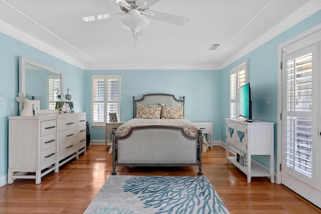 bedroom with wood-type flooring, ornamental molding, and ceiling fan