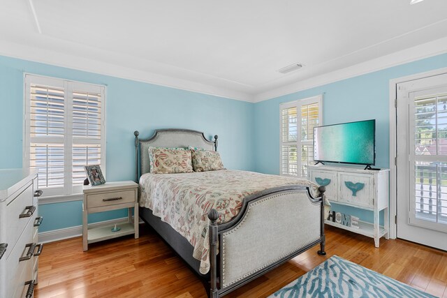 bedroom featuring multiple windows and light hardwood / wood-style floors