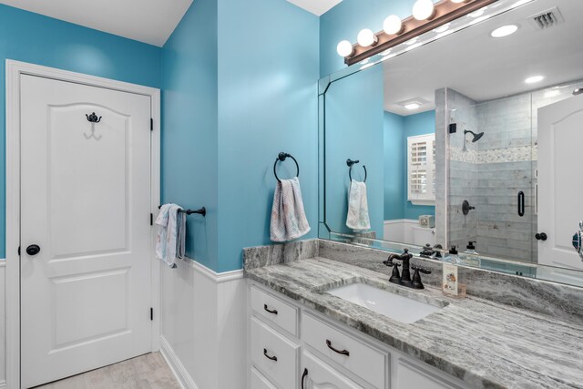 bathroom with walk in shower, tile patterned floors, and vanity