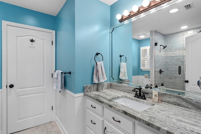 bathroom featuring vanity, a shower with shower door, and wood-type flooring