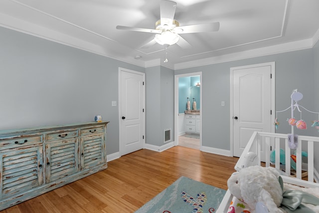 bedroom featuring connected bathroom, light wood-type flooring, crown molding, and ceiling fan