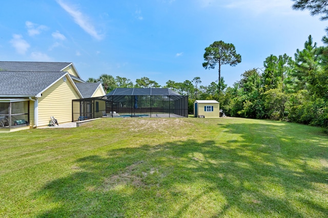 view of yard with glass enclosure, a pool, and a patio area