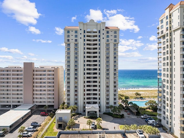 exterior space featuring a water view, a view of the beach, and a community pool