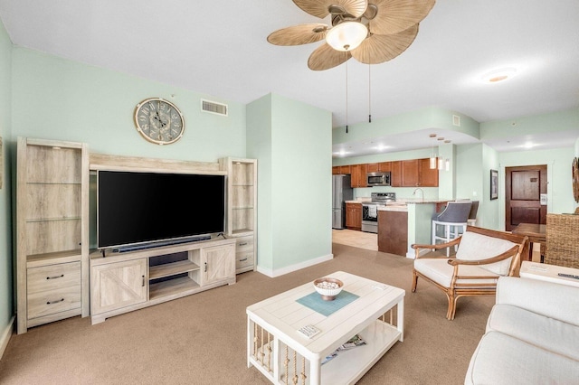 carpeted living room with ceiling fan and sink