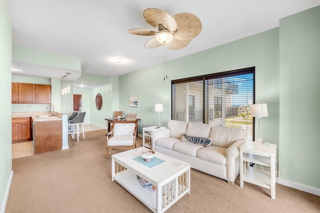 living room with light carpet, sink, and ceiling fan