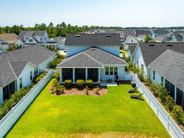 back of property featuring a lawn, a patio, and a sunroom