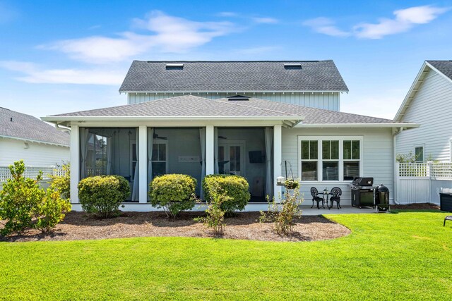 rear view of house with a sunroom, a yard, and a patio