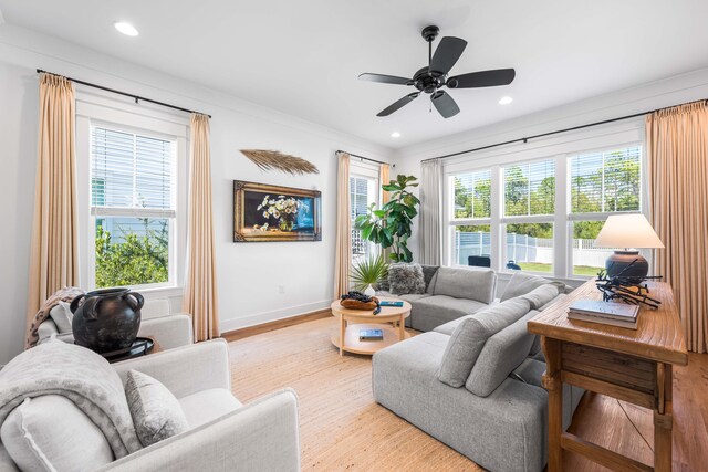 living room featuring light wood-type flooring, ceiling fan, and plenty of natural light