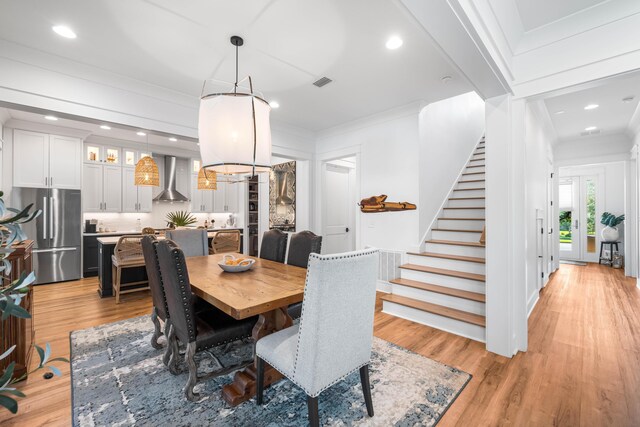 dining area featuring light hardwood / wood-style floors and ornamental molding