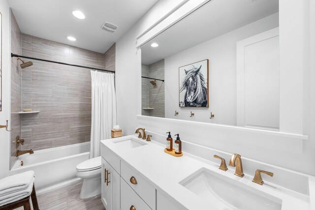 full bathroom featuring vanity, shower / tub combo, and toilet