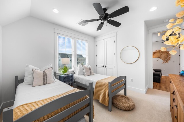 bedroom with light carpet, lofted ceiling, a closet, and ceiling fan